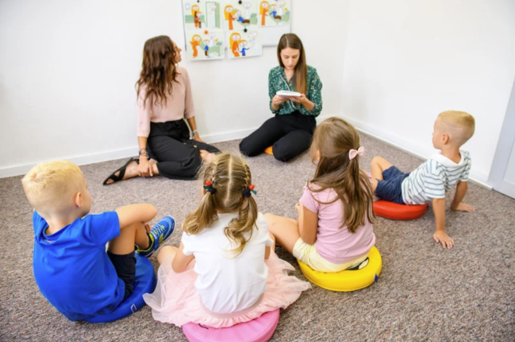 Young children in circle time with therapist