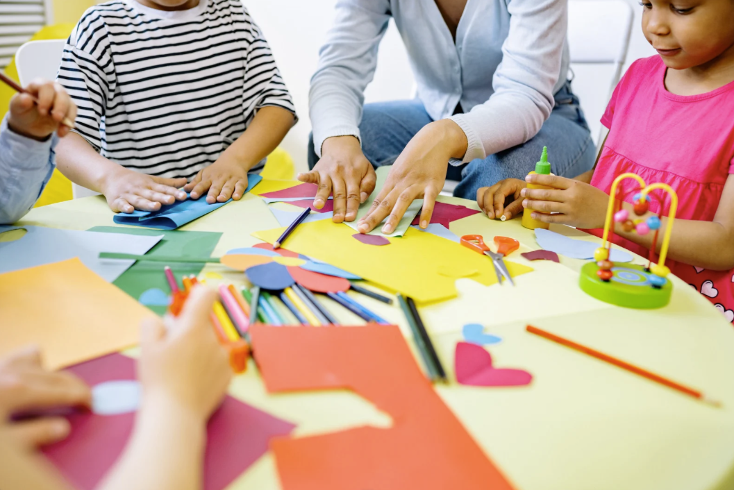 Children doing crafts together at a colorful table