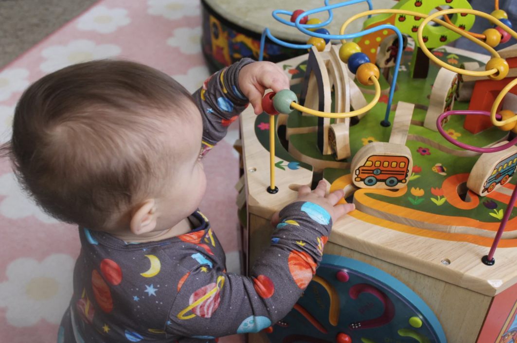 Toddler exploring a colorful activity cube